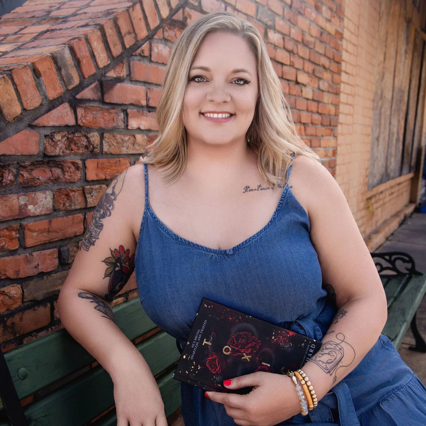 Nicole Blanchard, wearing a blue dress and holding a book.