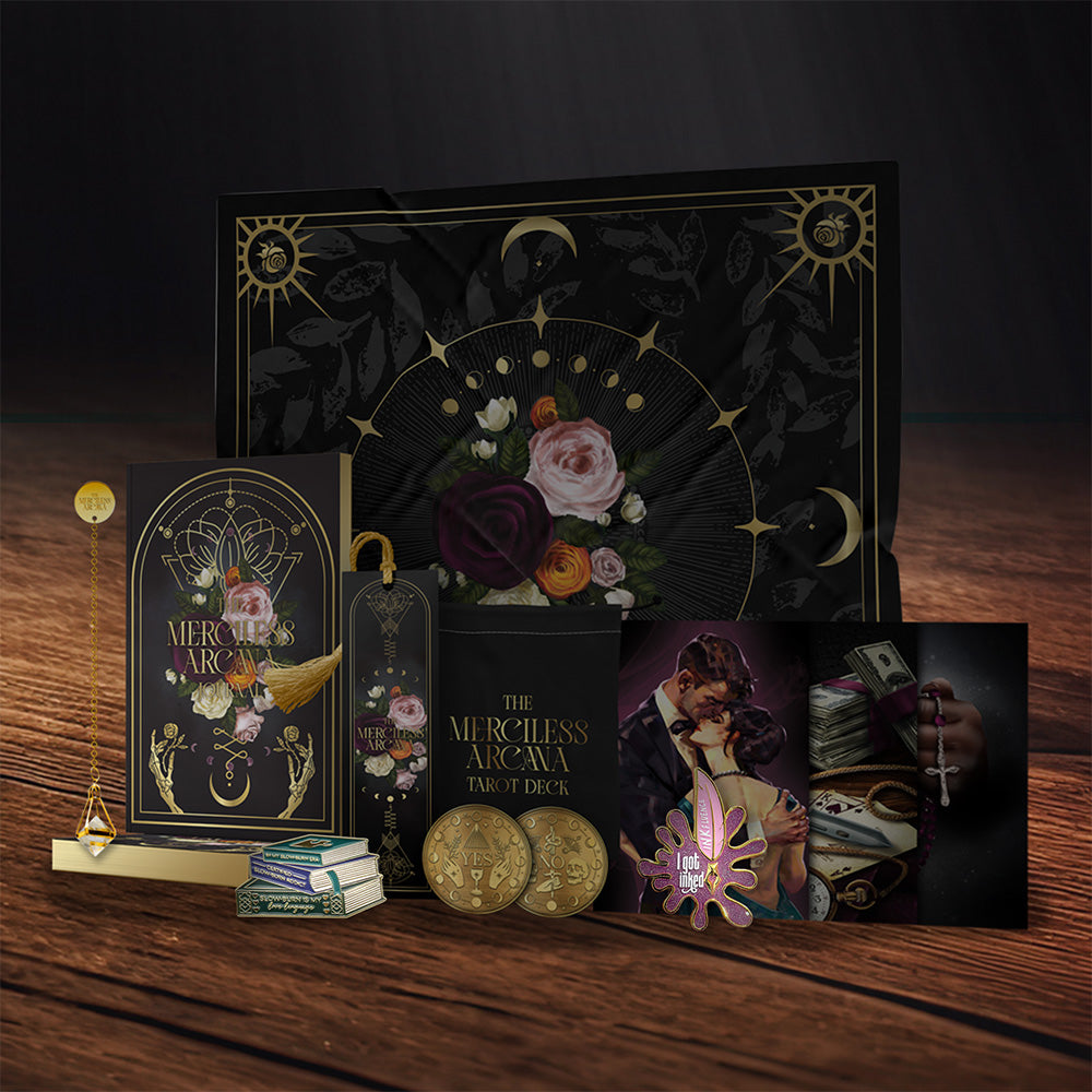Collection of decorative items including books, pins, a box, and cards on a wooden surface with a dark background.